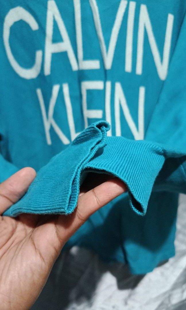 CALVIN KLEIN (Category: Activewear) located in Mandaluyong City. Submitted by newdepot (Listing ID 1464509517, Image 3). Description: Calvin Klein knit long-sleeve sweater featuring a prominent white block logo across the chest Small 20*24 Shoulder to wrist 22.