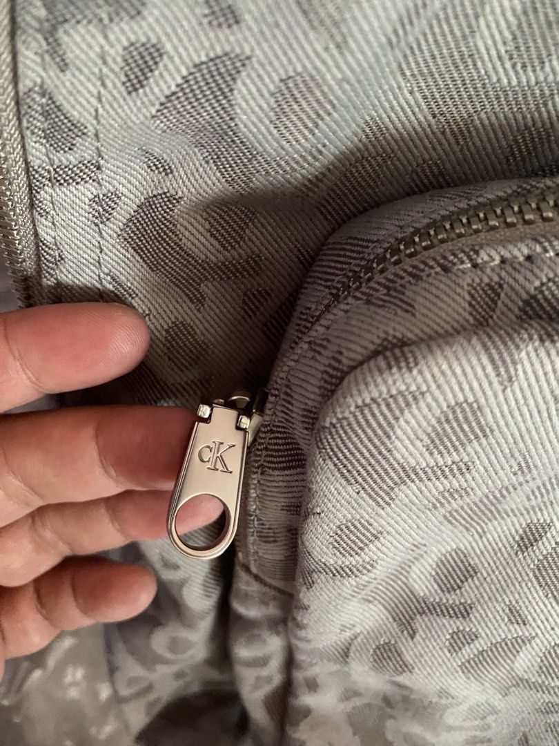Calvin Klein CK Monogram Grey Backpack (Category: Backpacks) located in Pasig City. Submitted by bartbuy (Listing ID 1464361380, Image 2). Description: - Grey Calvin Klein backpack - All-over CK monogram pattern - Front zip pocket - Main compartment - Adjustable shoulder straps - CK logo zipper pulls - Ideal for everyday use - Unisex - Bought in USA - can fit up to 13 inches laptop - used once only good as new.