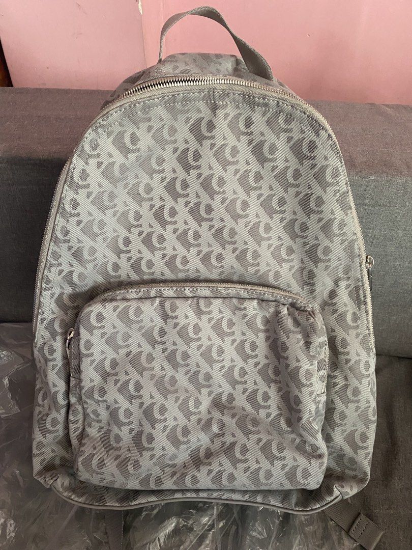 Calvin Klein CK Monogram Grey Backpack (Category: Backpacks) located in Pasig City. Submitted by bartbuy (Listing ID 1464361380, Image 1). Description: - Grey Calvin Klein backpack - All-over CK monogram pattern - Front zip pocket - Main compartment - Adjustable shoulder straps - CK logo zipper pulls - Ideal for everyday use - Unisex - Bought in USA - can fit up to 13 inches laptop - used once only good as new.
