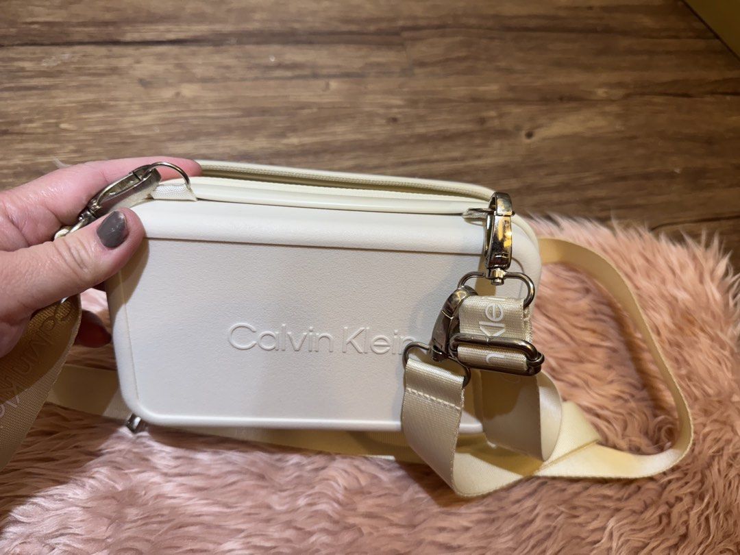 Calvin Klein Cream Cosmetic Bag with Strap (Category: Purses & Pouches) located in Dasmarinas. Submitted by rinz0man (Listing ID 1464402642, Image 2). Description: - Cream Calvin Klein cosmetic bag - Secure zip closure - Detachable strap with iconic Calvin Klein logo - Convenient inner mesh pocket - Ideal for travel or everyday organization - Excellent, clean condition inside and out.