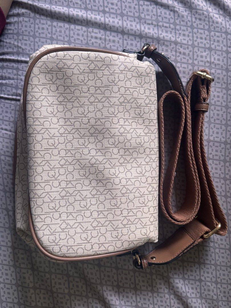 Calvin Klein Monogram Crossbody Bag (Category: Cross-body Bags) located in Obando. Submitted by Wintermelonzzzz (Listing ID 1464370589, Image 2). Description: ❗️Not sure if authentic❗️ - Features iconic all-over CK monogram print - Stylish tan trim and adjustable strap - Elegant gold hardware closure - Interior includes CK tag and secure zipper pocket - Ideal for everyday use and carrying essentials.