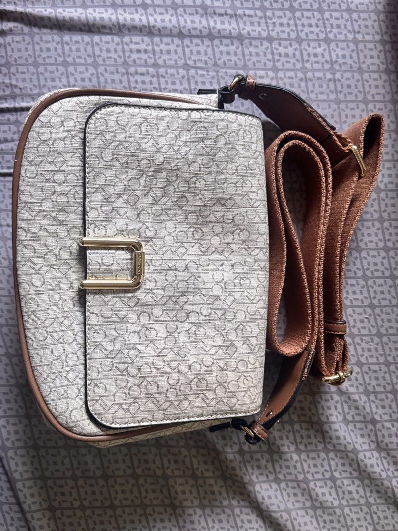 Calvin Klein Monogram Crossbody Bag (Category: Cross-body Bags) located in Obando. Submitted by Wintermelonzzzz (Listing ID 1464370589, Image 1). Description: ❗️Not sure if authentic❗️ - Features iconic all-over CK monogram print - Stylish tan trim and adjustable strap - Elegant gold hardware closure - Interior includes CK tag and secure zipper pocket - Ideal for everyday use and carrying essentials.
