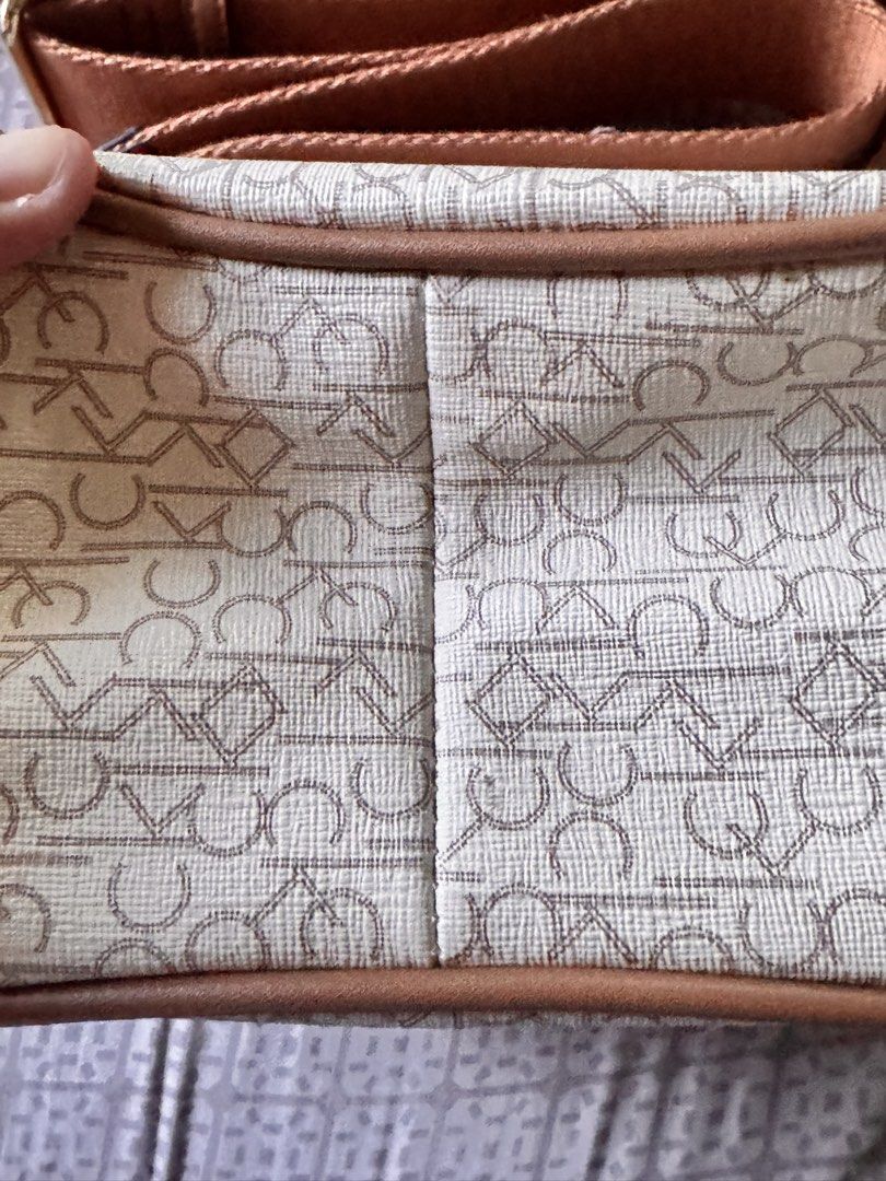 Calvin Klein Monogram Crossbody Bag (Category: Cross-body Bags) located in Obando. Submitted by Wintermelonzzzz (Listing ID 1464370589, Image 3). Description: ❗️Not sure if authentic❗️ - Features iconic all-over CK monogram print - Stylish tan trim and adjustable strap - Elegant gold hardware closure - Interior includes CK tag and secure zipper pocket - Ideal for everyday use and carrying essentials.