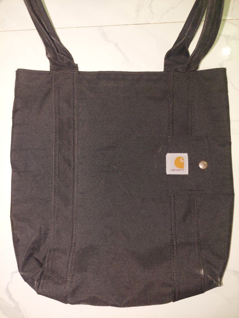 Carhartt Black Canvas Tote Bag (Category: Tote Bags) located in Manila. Submitted by okeanos (Listing ID 1464478937, Image 1). Description: - Bought in USA - Original and 100% authenthic - There's a slight fade at the opening of the tote bag -You can also make a offer - Ideal for everyday use, shopping, or carrying essentials - Shows some signs of wear inside, exterior in good shape - Reliable and practical.