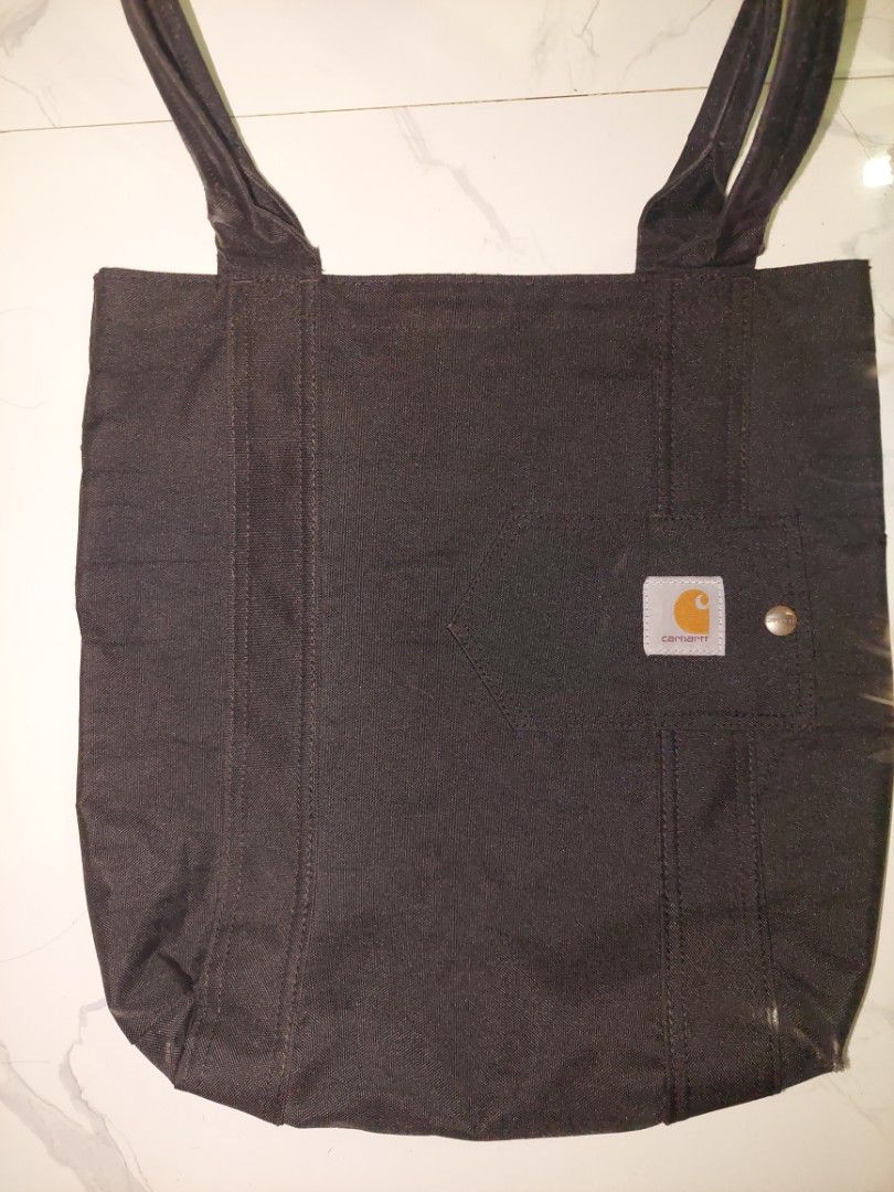 Carhartt Black Canvas Tote Bag (Category: Tote Bags) located in Manila. Submitted by okeanos (Listing ID 1464478937, Image 2). Description: - Bought in USA - Original and 100% authenthic - There's a slight fade at the opening of the tote bag -You can also make a offer - Ideal for everyday use, shopping, or carrying essentials - Shows some signs of wear inside, exterior in good shape - Reliable and practical.