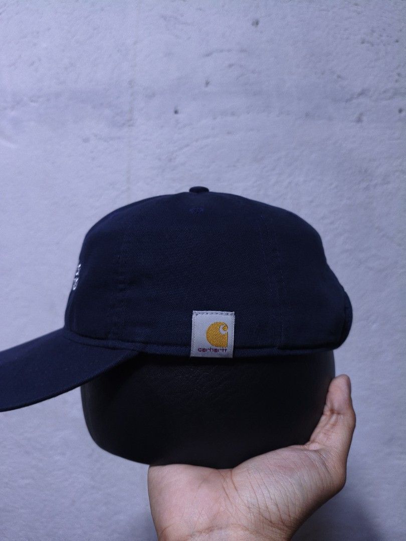Carhartt Navy Blue Cap (Category: Caps & Hats) located in Malilipot. Submitted by aronbigorn96320 (Listing ID 1464470249, Image 2). Description: - Navy blue cap with white 'SH' embroidery - 'Mi Casa Su Casa' text detail - Carhartt logo on side and back - Made from 100% cotton - From the Spring 2023 collection - Adjustable strap for a comfortable fit.