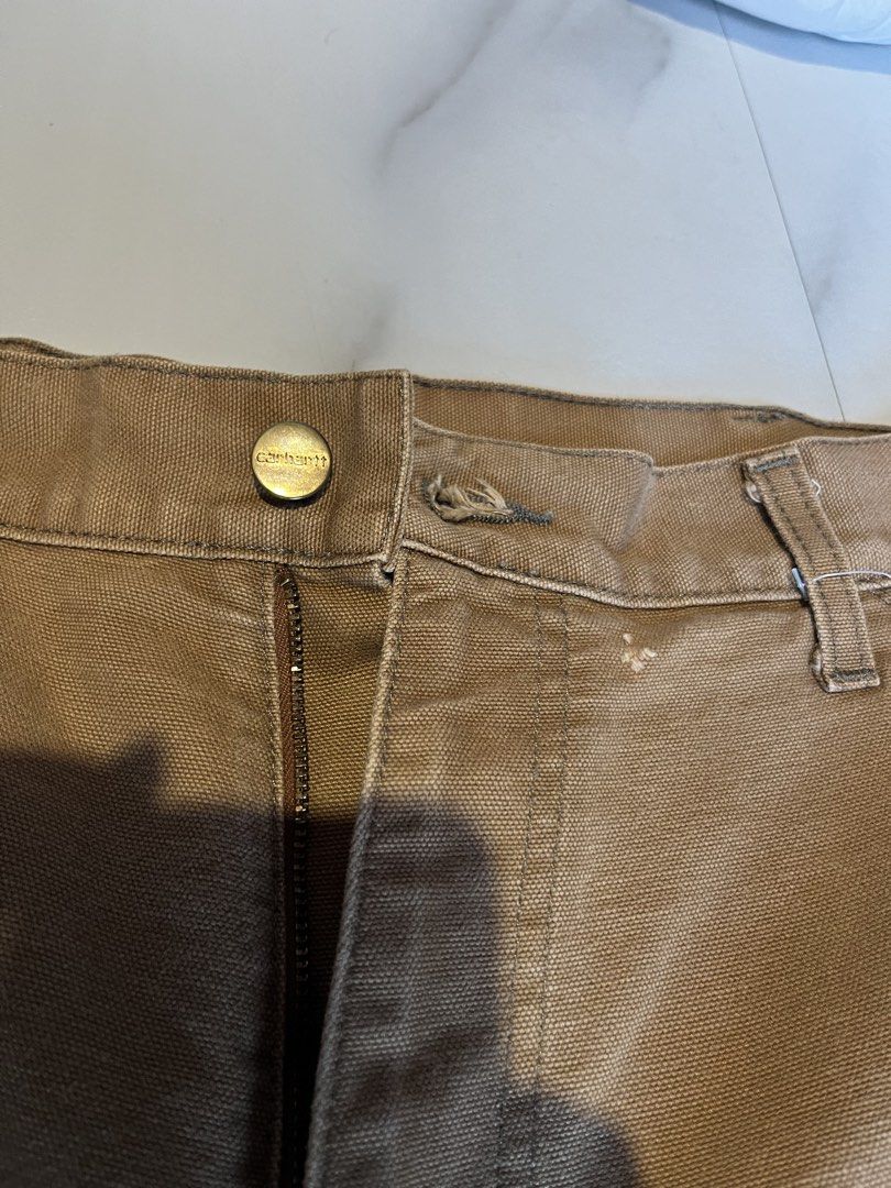 Carhartt Work Pants Tan Carpenter Double Knee (Category: Jeans) located in Cavite. Submitted by christianzuuu (Listing ID 1464497089, Image 3). Description: - Issues on bottom part and faded tag - Carhartt work pants - Color: Tan - Style: Carpenter - Features: Double knees - Condition: Some wear on hems, a few small marks on front - Classic, durable workwear - Perfect for your next project.