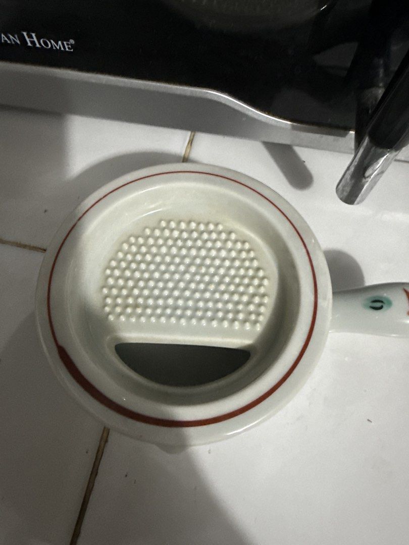 Ceramic Grater Bowl with Handle and Lid (Category: Cookware & Accessories) located in Tuguegarao City. Submitted by purrposeph (Listing ID 1464457079, Image 3). Description: - Cute ceramic bowl with built-in grater - Features a handle for easy grip - Includes a lid for convenience - Ideal for grating garlic, ginger, or cheese - Stylish white design with red accents and a charming duck-like handle - A practical addition to your kitchen prep tools.