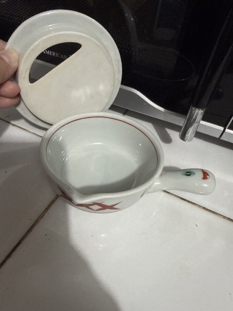 Ceramic Grater Bowl with Handle and Lid (Category: Cookware & Accessories) located in Tuguegarao City. Submitted by purrposeph (Listing ID 1464457079, Image 2). Description: - Cute ceramic bowl with built-in grater - Features a handle for easy grip - Includes a lid for convenience - Ideal for grating garlic, ginger, or cheese - Stylish white design with red accents and a charming duck-like handle - A practical addition to your kitchen prep tools.
