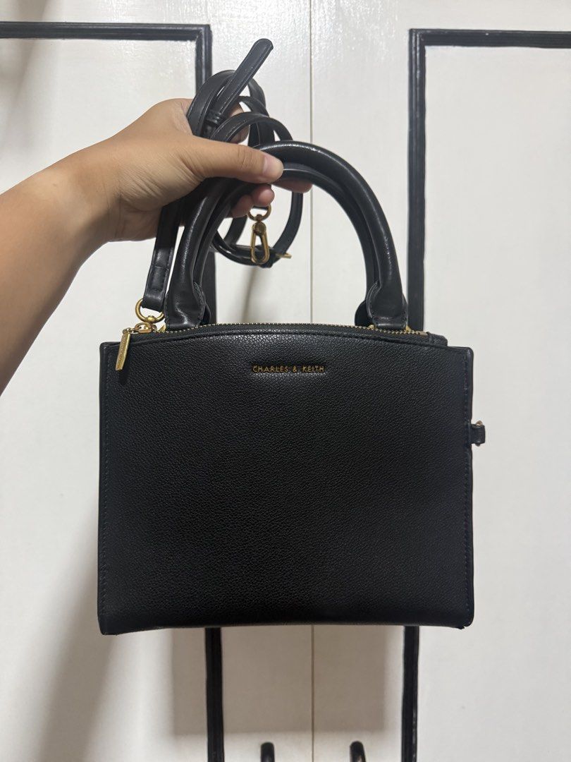 Charles & Keith Black Top Handle Bag (Category: Tote Bags) located in Taytay. Submitted by phoebspreloved (Listing ID 1464501644, Image 1). Description: - Brand: Charles & Keith - Color: Black - Style: Top handle bag - Closure: Zip closure - Strap: Detachable shoulder strap - Interior: Zip pocket - Hardware: Gold details - Versatile: Ideal for everyday or evening use.