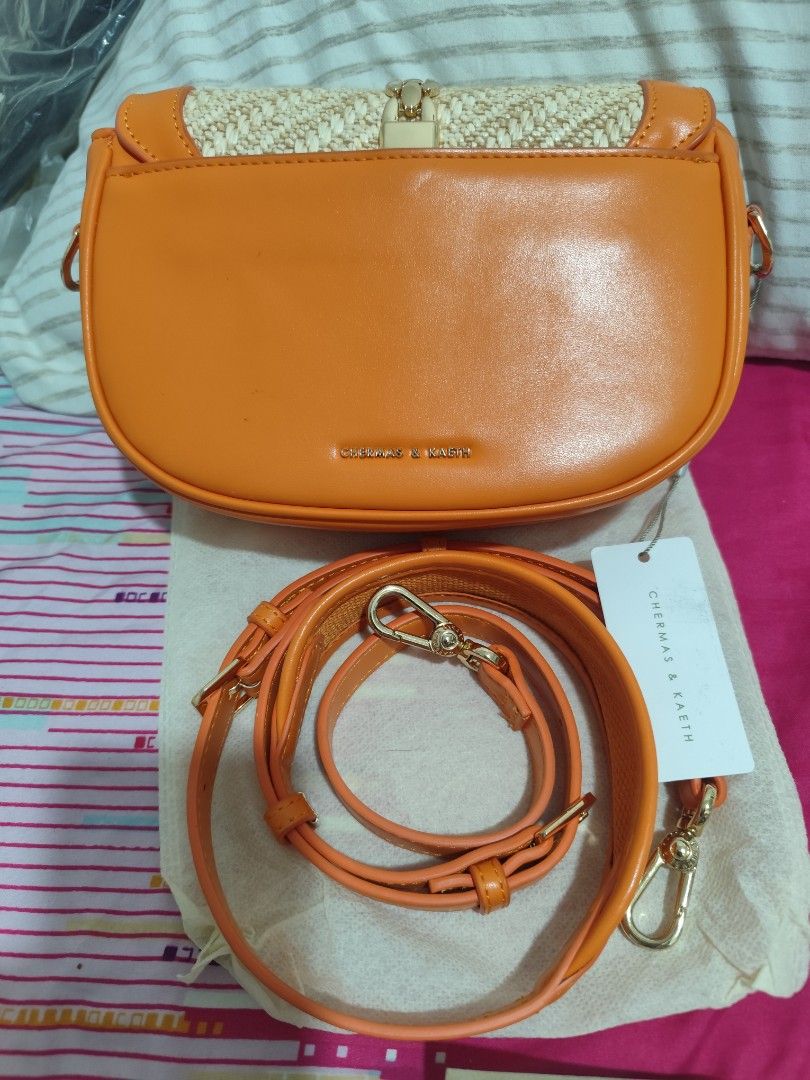 Chermas & Keith Orange Woven Flap Bag (Category: Shoulder Bags) located in Manila. Submitted by marriage031073advocate (Listing ID 1464457608, Image 2). Description: - Preloved orange flap bag like-new - Features woven detail on the front - Elegant gold hardware and clasp closure - Includes an adjustable crossbody strap - Versatile for casual or dressed-up looks - Tags still attached - No Issue.