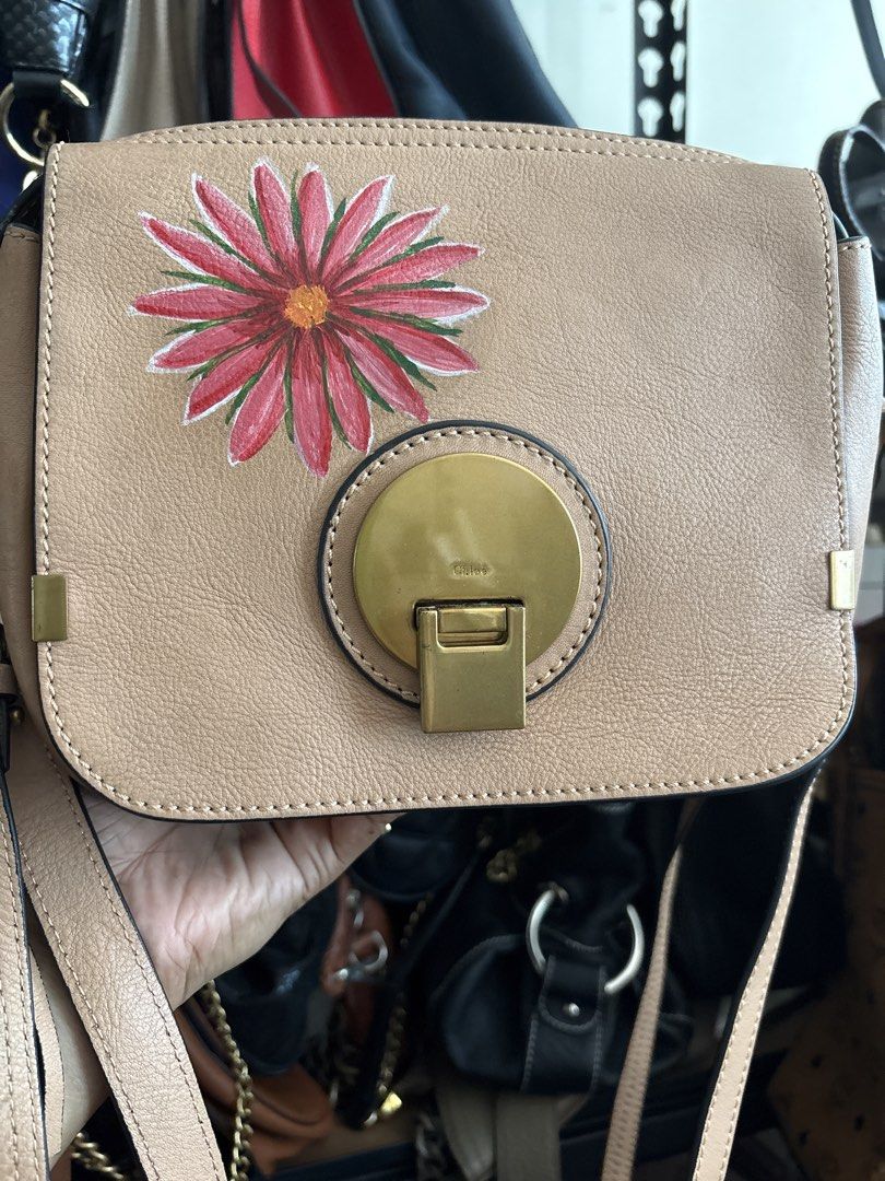 Chloe Small Tan Leather Bag with Hand-Painted Flower (Category: Luxury Bags & Wallets) located in Cordova. Submitted by cb_bagz_n_bloom (Listing ID 1464358342, Image 1). Description: - Chloe tan leather crossbody bag - Unique hand-painted red and pink flower on front flap - Elegant gold hardware closure - Adjustable strap for comfortable wear - Versatile: ideal for daily errands or evening outings.