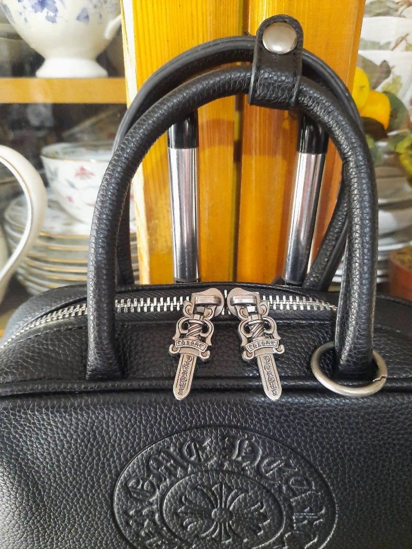 Chrome Hearts Black Leather Handbag (Category: Luxury Bags & Wallets) located in Manila. Submitted by boldfire_315559 (Listing ID 1464361199, Image 3). Description: - Genuine black leather handbag - Authentic Chrome Hearts detailing - Iconic circular logo on front - Metal plate on back - Silver hardware with dagger zipper pulls - Top handles for easy carrying - Detachable shoulder strap for versatility - Small and compact size, perfect for essent