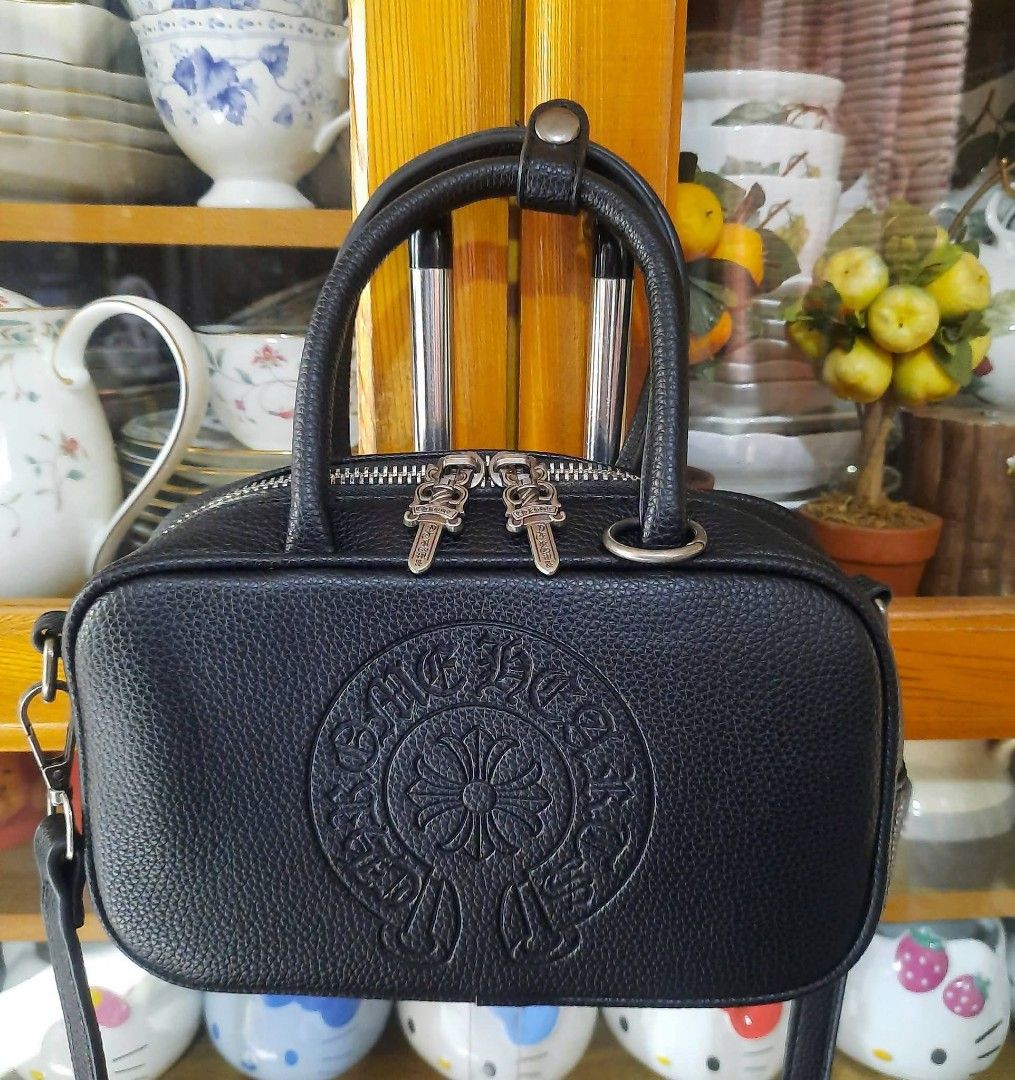 Chrome Hearts Black Leather Handbag (Category: Luxury Bags & Wallets) located in Manila. Submitted by boldfire_315559 (Listing ID 1464361199, Image 1). Description: - Genuine black leather handbag - Authentic Chrome Hearts detailing - Iconic circular logo on front - Metal plate on back - Silver hardware with dagger zipper pulls - Top handles for easy carrying - Detachable shoulder strap for versatility - Small and compact size, perfect for essent