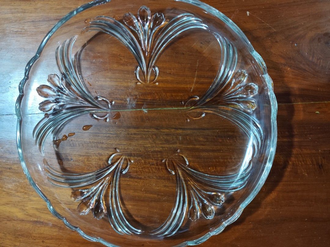 Clear Glass Serving Platter with Embossed Floral Design (Category: Dinnerware & Cutlery) located in Manila. Submitted by marriage031073advocate (Listing ID 1464453407, Image 1). Description: - Round clear glass serving platter - Features embossed floral pattern and scalloped edges - Ideal for serving appetizers, desserts, or snacks - Versatile clear glass complements any table setting - Imported.