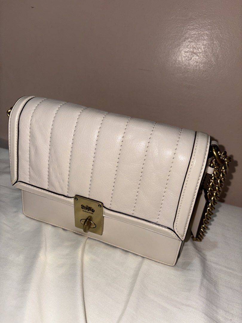 Coach Hutton Quilted Leather Shoulder Bag with Chain Strap (Category: Luxury Bags & Wallets) located in Munoz. Submitted by meowmeowmeowmeowz (Listing ID 1464480234, Image 2). Description: SRP 24k+ -Creamy white quilted leather shoulder bag by Coach - Gold turn-lock closure with iconic horse and carriage logo - Comfortable chain strap with leather shoulder pad - Interior zip pocket for essentials - Coach creed patch for authenticity - Versatile s