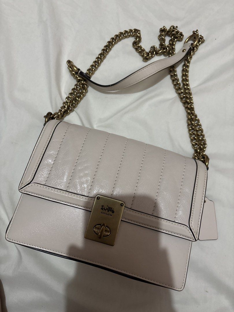 Coach Hutton Quilted Leather Shoulder Bag with Chain Strap (Category: Luxury Bags & Wallets) located in Munoz. Submitted by meowmeowmeowmeowz (Listing ID 1464480234, Image 1). Description: SRP 24k+ -Creamy white quilted leather shoulder bag by Coach - Gold turn-lock closure with iconic horse and carriage logo - Comfortable chain strap with leather shoulder pad - Interior zip pocket for essentials - Coach creed patch for authenticity - Versatile s