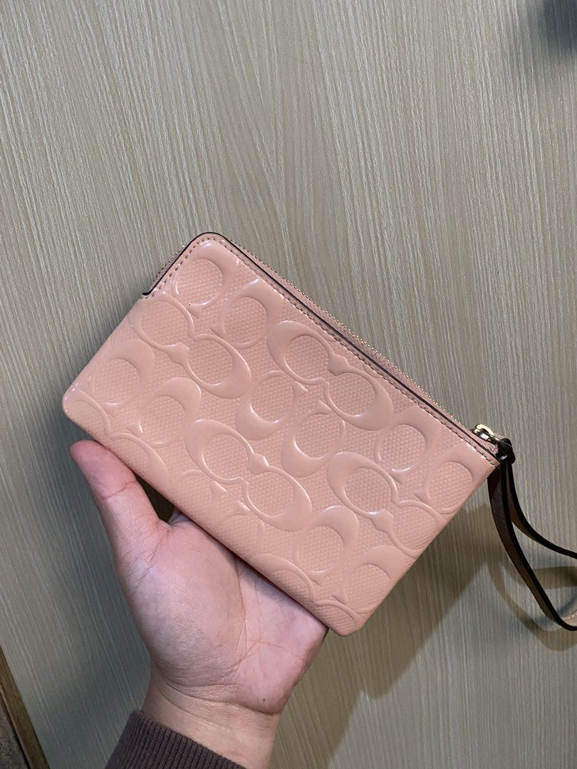 Coach Pink Monogram Wristlet Pouch (Category: Luxury Bags & Wallets) located in La Trinidad. Submitted by kinleyky (Listing ID 1464388398, Image 2). Description: - Coach wristlet in a lovely light pink. - Features the iconic Coach C monogram embossed all over. - Secure zip closure with a convenient wrist strap. - Interior pocket for organizing small items. - Comes with an authenticity card for peace of mind. - Ideal for carrying your daily essent