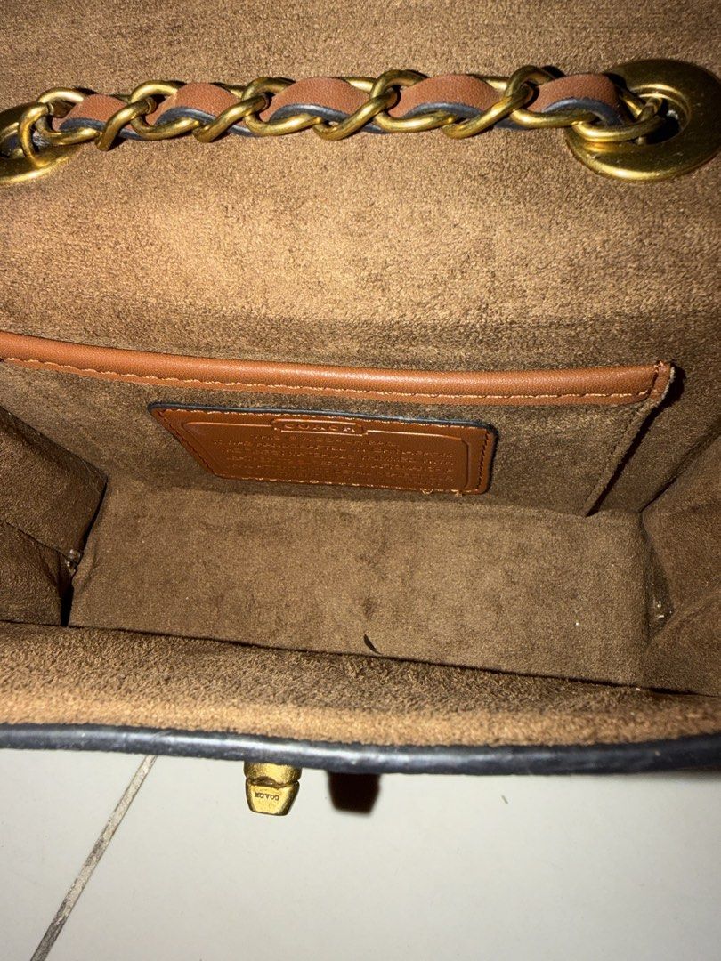 Coach Signature Canvas & Leather Chain Bag (Category: Luxury Bags & Wallets) located in Santa Rosa. Submitted by decluttering_. (Listing ID 1464568277, Image 2). Description: - Authentic Coach bag - Signature print with white leather flap - Gold chain strap with leather accents - Brown suede-like interior lining - Small interior compartment - Secure clasp closure - Ideal for carrying essentials.