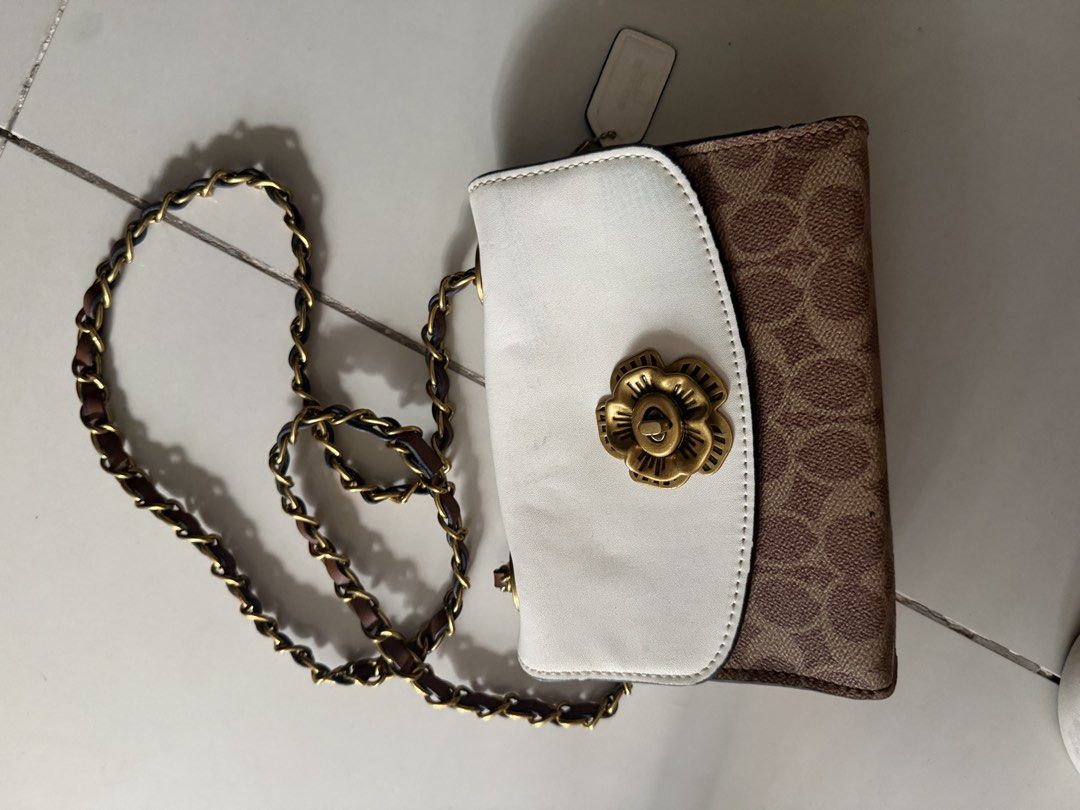 Coach Signature Canvas & Leather Chain Bag (Category: Luxury Bags & Wallets) located in Santa Rosa. Submitted by decluttering_. (Listing ID 1464568277, Image 1). Description: - Authentic Coach bag - Signature print with white leather flap - Gold chain strap with leather accents - Brown suede-like interior lining - Small interior compartment - Secure clasp closure - Ideal for carrying essentials.