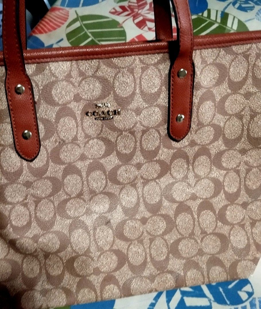 Coach Signature Tote Bag (Category: Tote Bags) located in Manila. Submitted by lene48 (Listing ID 1464487426, Image 2). Description: - Classic Coach tote bag - Signature C pattern all over - Brown and tan colorway - Genuine leather trim and handles - Secure zipper closure - Interior features a zippered pocket and slip pockets - Ideal for everyday use.