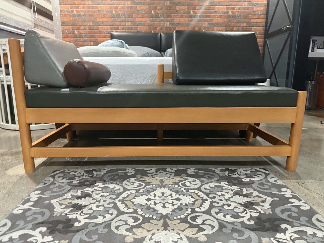 Custom Wooden Frame Daybed with Cushions (Category: Bed Frames & Mattresses) located in Quezon City. Submitted by thejowsh (Listing ID 1464386343, Image 2). Description: - Wooden frame daybed with natural finish - Dark grey upholstery - Includes one bolster pillow - Includes two back cushions (grey and black) - Simple, modern design - Ideal for lounging or extra seating - Fits most living spaces.