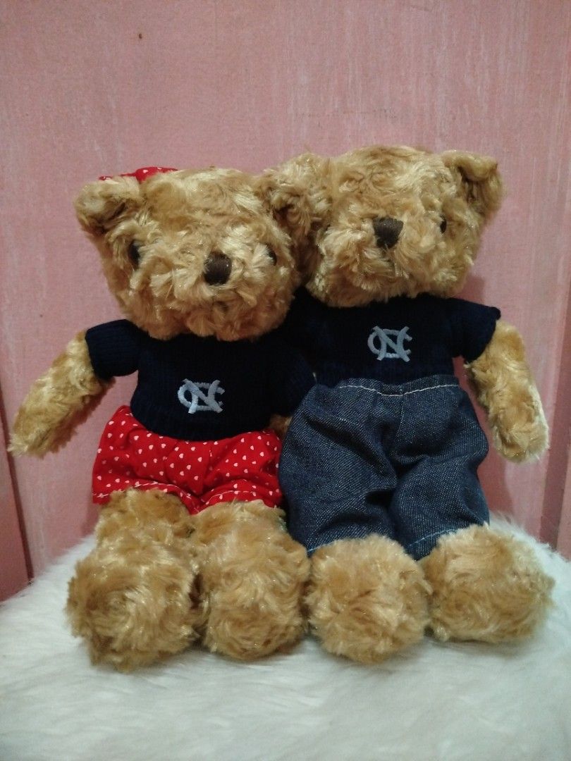 Cute Couple Teddy Bears with Matching Outfits (Category: Plushies & Soft Toys) located in Pasig City. Submitted by chinchan1 (Listing ID 1464368827, Image 1). Description: - Adorable teddy bear duo - Bear 1: Red polka dot skirt, navy shirt with white embroidered logo - Bear 2: Denim pants, navy shirt with white embroidered logo - Ideal for display or as a gift - Super cuddly appearance.