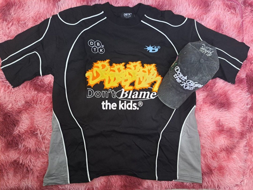 DBTK "Don't Blame the Kids" Bundle (Category: Tshirts & Polo Shirts ) located in Manila. Submitted by unbotheredave (Listing ID 1464378843, Image 3). Description: Disclutter 2times used tambak lang. Fix price - Black DBTK T-shirt with unique camo accents. - Front features the iconic "Don't Blame the Kids" graphic. - Back design includes the number "12" and the DBTK logo. - Comes with a matching DBTK cap, completing the look. - Ideal for your stre