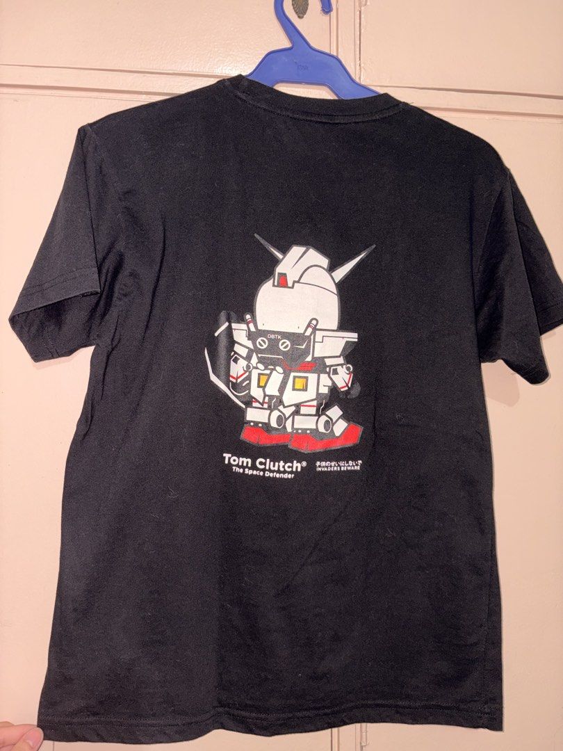 DBTK Tom Clutch The Space Defender T-Shirt (Category: Tshirts & Polo Shirts ) located in Quezon City. Submitted by jonahmerri16576 (Listing ID 1464386881, Image 2). Description: - Black DBTK t-shirt - Features a cool Tom Clutch graphic on front and back - Gundam-inspired design with 'The Space Defender' text - Includes Japanese characters - Perfect for anime fans and unique graphic tee collectors - DBTK logo visible on the collar - Tag detail on 