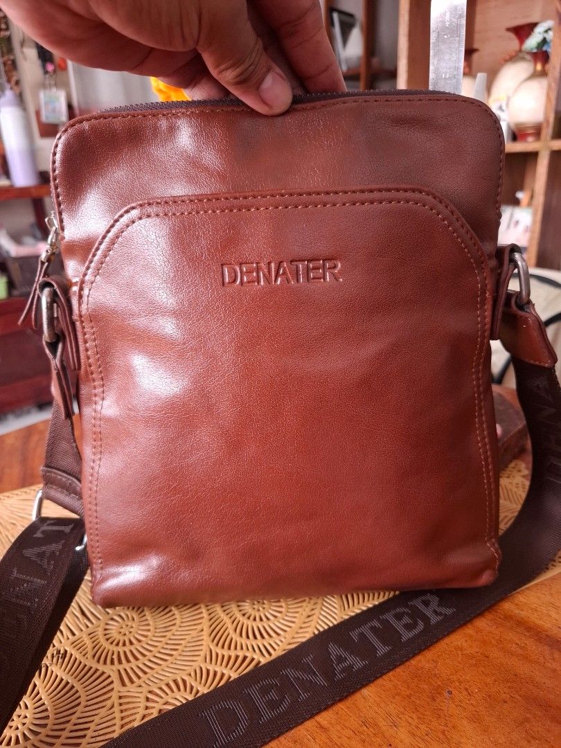 DENATER Brown Leather Crossbody Bag (Category: Sling Bags) located in Libon. Submitted by jaladzarmi80045 (Listing ID 1464361674, Image 3). Description: - DENATER brown leather crossbody bag - Adjustable strap with brand name - Main compartment with zipper closure - Front pocket for quick access - Perfect for everyday use - Please check photos for condition details.
