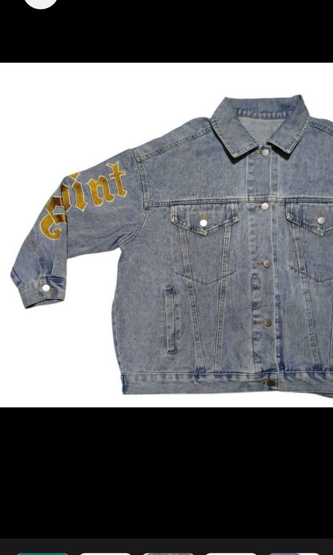 DENIM JACKET WITH SLEEVE DESIGN (Category: Coats, Jackets and Outerwear) located in Quezon City. Submitted by zoesmithshop (Listing ID 1464515930, Image 2). Description: - Light blue denim jacket - Features a Doraemon design on the back - Gold lettering on the sleeves - Classic denim jacket design - Button closures and pockets - Stylish and eye-catching.