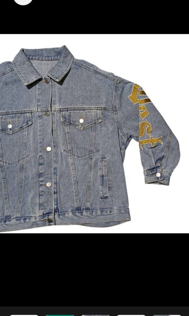 DENIM JACKET WITH SLEEVE DESIGN (Category: Coats, Jackets and Outerwear) located in Quezon City. Submitted by zoesmithshop (Listing ID 1464515930, Image 1). Description: - Light blue denim jacket - Features a Doraemon design on the back - Gold lettering on the sleeves - Classic denim jacket design - Button closures and pockets - Stylish and eye-catching.