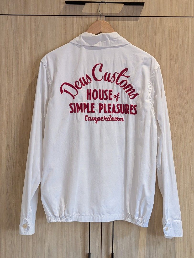 DEUS EX MACHINA Gulf Drizzler Jacket (L) (Category: Coats, Jackets and Outerwear) located in Pasay City. Submitted by bottomdrawermnl (Listing ID 1464409966, Image 3). Description: DEUS EX MACHINA Drizzler Jacket (L) (White/Red) Dimensions: Length: 68cm Shoulder: 47cm Chest P2P: 58cm Sleeve length: 66cm Details: - Condition: 10/10 (used once) - Deus Customs logo on front - 'House of Simple Pleasures Camperdown' red stitching on back - Zip-up fron