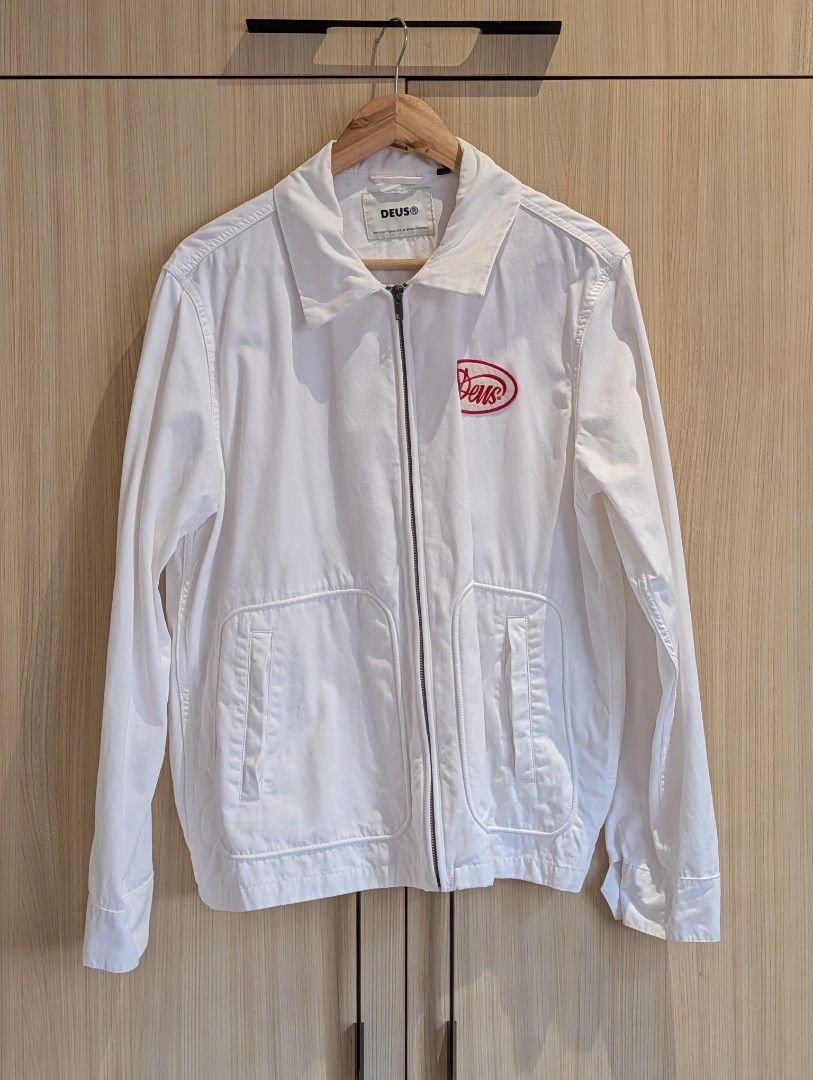 DEUS EX MACHINA Gulf Drizzler Jacket (L) (Category: Coats, Jackets and Outerwear) located in Pasay City. Submitted by bottomdrawermnl (Listing ID 1464409966, Image 2). Description: DEUS EX MACHINA Drizzler Jacket (L) (White/Red) Dimensions: Length: 68cm Shoulder: 47cm Chest P2P: 58cm Sleeve length: 66cm Details: - Condition: 10/10 (used once) - Deus Customs logo on front - 'House of Simple Pleasures Camperdown' red stitching on back - Zip-up fron