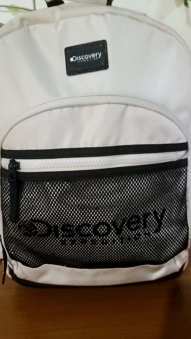 Discovery Backpack (Category: Backpacks) located in Baguio. Submitted by phoeberose33384 (Listing ID 1464567694, Image 2). Description: - White Discovery backpack - Side mesh pocket with Discovery logo - Light stains on the front - Protective studs on the bottom - Ideal for everyday use.