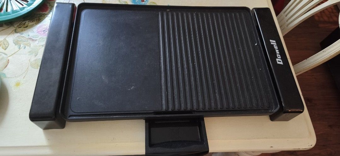 Dowell Flat Indoor Electric Grill (Category: BBQ, Grills & Hotpots) located in Quezon City. Submitted by lilyofthevalley.1129am (Listing ID 1464358265, Image 1). Description: - Dowell Electric Grill - Reversible plate: flat griddle on one side, grill lines on the other - Versatile for cooking various foods - Easy to clean - Compact size for easy storage - Perfect for small kitchens or dorm rooms - Power Wattage: 2050 WattsRated Voltage/Frequency: