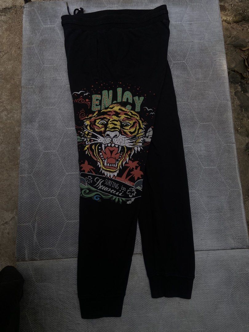 Ed Hardy Black Tiger & Dolphin Print Sweatpants (Category: Joggers) located in Manila. Submitted by thriftsomesht111 (Listing ID 1464455154, Image 3). Description: - Black sweatpants featuring iconic Ed Hardy graphics. - Bold tiger design on one leg. - Ed Hardy logo with a dolphin on the other leg. - Comfortable drawstring waist for an adjustable fit. - Ideal for casual outings or relaxing at home..