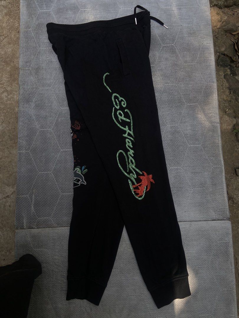 Ed Hardy Black Tiger & Dolphin Print Sweatpants (Category: Joggers) located in Manila. Submitted by thriftsomesht111 (Listing ID 1464455154, Image 2). Description: - Black sweatpants featuring iconic Ed Hardy graphics. - Bold tiger design on one leg. - Ed Hardy logo with a dolphin on the other leg. - Comfortable drawstring waist for an adjustable fit. - Ideal for casual outings or relaxing at home..