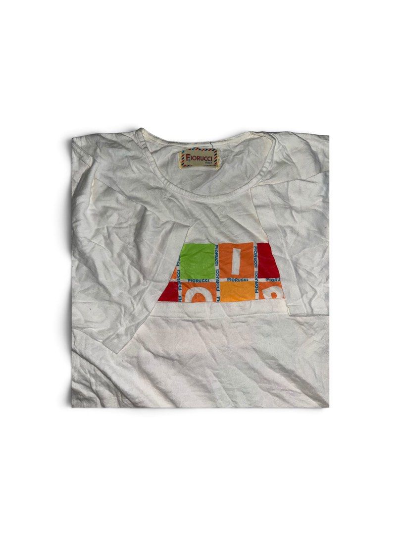 Fiorucci White Graphic T-Shirt (Category: Shirts) located in Nabua. Submitted by lastthrift2.0 (Listing ID 1464515090, Image 2). Description: Dimes•22x25 Single stitch - White Fiorucci t-shirt - Colorful graphic print with letters in squares on the front - Short sleeves - Crew neck - Made of comfortable cotton - Ideal for casual wear.