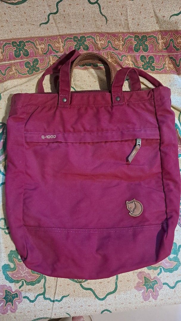 Fjallraven G-1000 Tote Bag (Category: Tote Bags) located in Cavite. Submitted by naning049 (Listing ID 1464426158, Image 1). Description: - Fjallraven tote bag in a rich deep berry color. - Crafted from durable G-1000 material. - Features stylish leather accents on the handles. - Convenient front zippered pocket for quick access. - Main compartment zips securely closed. - Perfect everyday size. needs a bit of cleaning PWEDE BACK PACK PWEDE TOTE B