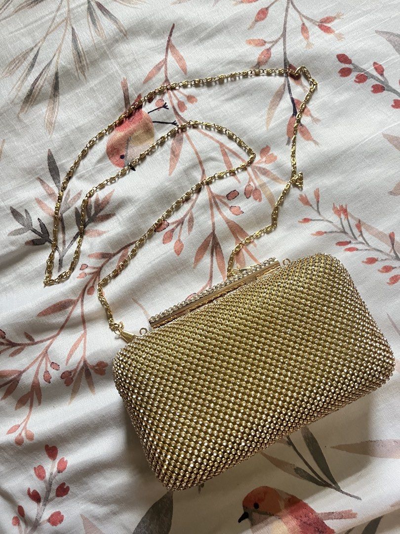 Gold Rhinestone Clutch Bag with Chain Strap (Category: Clutches) located in Binangonan. Submitted by heraaa21 (Listing ID 1464367724, Image 1). Description: Sparkly gold clutch bag. Covered in rhinestones all over. Comes with a detachable gold chain strap. Has a magnetic closure. Inside is lined with satin. Great for parties or special occasions. Small enough to hold in your hand or wear on your shoulder..