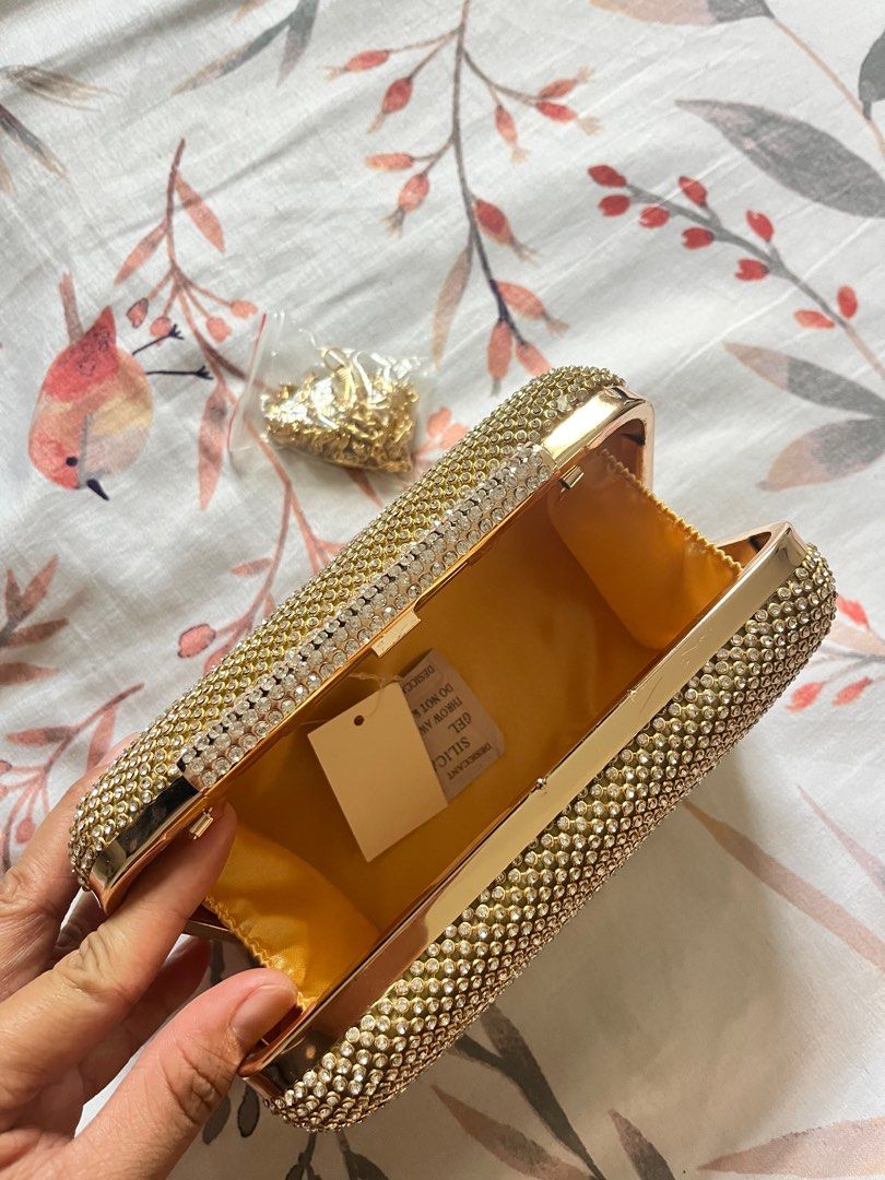Gold Rhinestone Clutch Bag with Chain Strap (Category: Clutches) located in Binangonan. Submitted by heraaa21 (Listing ID 1464367724, Image 3). Description: Sparkly gold clutch bag. Covered in rhinestones all over. Comes with a detachable gold chain strap. Has a magnetic closure. Inside is lined with satin. Great for parties or special occasions. Small enough to hold in your hand or wear on your shoulder..