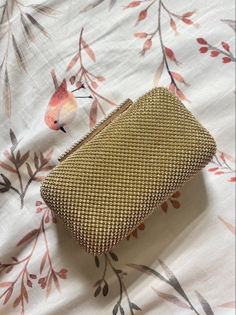 Gold Rhinestone Clutch Bag with Chain Strap (Category: Clutches) located in Binangonan. Submitted by heraaa21 (Listing ID 1464367724, Image 2). Description: Sparkly gold clutch bag. Covered in rhinestones all over. Comes with a detachable gold chain strap. Has a magnetic closure. Inside is lined with satin. Great for parties or special occasions. Small enough to hold in your hand or wear on your shoulder..