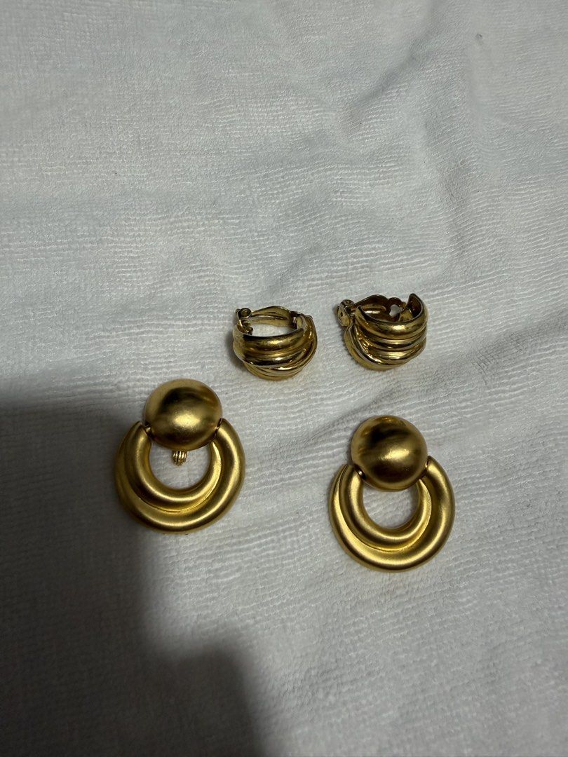 Gold Tone Clip-On Earrings Set (Category: Earrings) located in Digos. Submitted by old_soul. (Listing ID 1464498878, Image 1). Description: - Two pairs of gold tone clip-on earrings - Pair 1: Circular design with a ball accent - Pair 2: Ribbed, curved design - All pieces are clip-on style - Adds a vintage flair to any outfit.