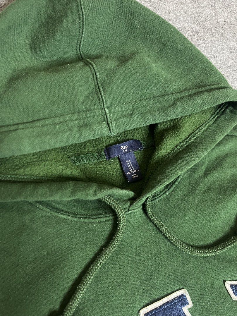 Green GAP Hoodie with Blue Logo (Category: Coats, Jackets and Outerwear) located in Lapu Lapu. Submitted by softfind (Listing ID 1464380732, Image 3). Description: Classic green GAP hoodie with blue/white logo, front pocket, and drawstring hood. Perfect for casual, comfy style. Size: Medium Dimes/inch Width: 22 Length: 27 Condition: 10/10 Color rate: 10/10 Issue: none .