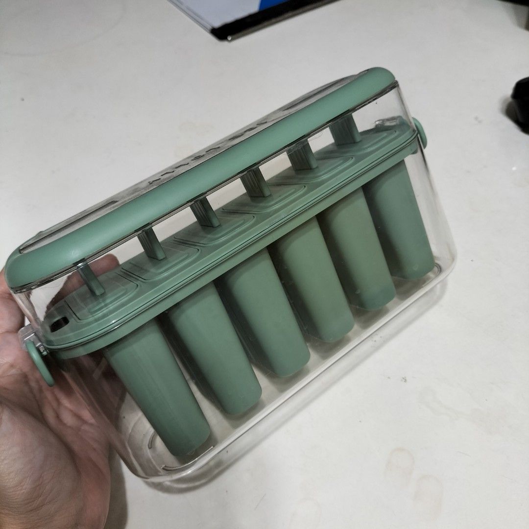 Green Popsicle Molds Ice Cream Maker with Container (Category: Food Organization & Storage) located in Paranaque City. Submitted by decluttering-all (Listing ID 1464566676, Image 1). Description: - Create your own delicious popsicles at home! - Set includes 6 individual popsicle molds. - Comes with a convenient container to keep molds organized in the freezer. - Simple to use and easy to clean. - Perfect for refreshing summer treats and experimen