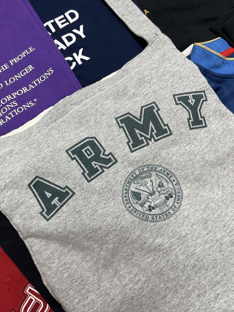 Grey ARMY Tote Bag with Zipper (Category: Tote Bags) located in Baao. Submitted by plainclothesdept (Listing ID 1464528284, Image 2). Description: Reworked Army Sling Bag width - 13 in. height - 14 in. from 100% cotton army tee no flaws - Grey tote bag with 'ARMY' graphic and US Army seal - Zipper closure for security - Cream-colored lining inside - Strap made of the same grey material - Crafted from a comfortable sweatshirt-like fabric - Ideal f