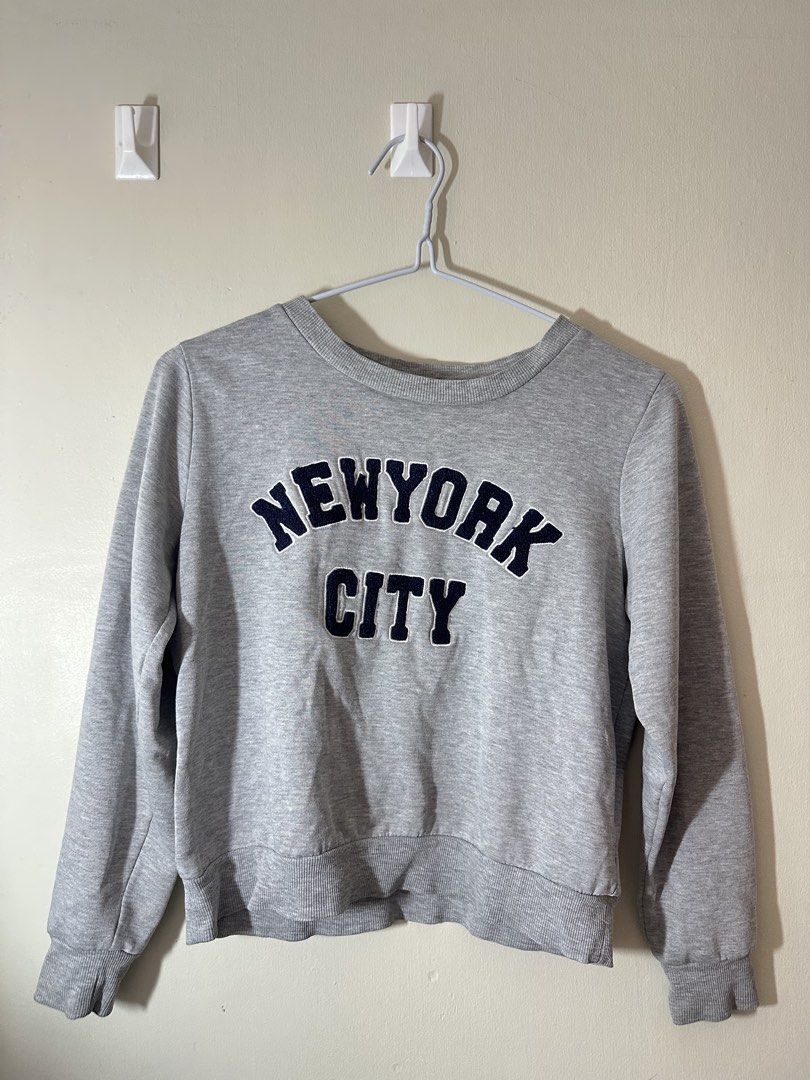 Grey New York City Sweatshirt (Category: Coats, Jackets and Outerwear) located in Baguio. Submitted by archivedbyj (Listing ID 1464390859, Image 1). Description: - Grey sweatshirt with 'New York City' graphic - Long sleeves with ribbed cuffs and hem - Casual and comfy design - Ideal for everyday wear - Easily pairs with jeans or leggings.