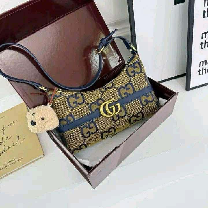 Gucci GG Monogram Shoulder Bag with Charm (Category: Luxury Bags & Wallets) located in Malabon City. Submitted by tinxoxo (Listing ID 1464527289, Image 1). Description: - Classic Gucci shoulder bag - Iconic brown and beige GG monogram pattern - Navy blue strap and trim - Comes with a cute fuzzy bear charm - Perfect size for essentials - Fits nicely in the box.