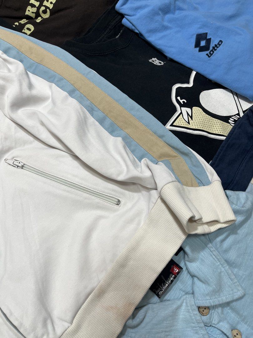 Guess White Track Jacket S/P (Category: Coats, Jackets and Outerwear) located in Baao. Submitted by plainclothesdept (Listing ID 1464534232, Image 3). Description: Guèss Full Zip Tracker Jacket width - 22 in. length - 24 in. discoloration, stains - White Guess track jacket - Blue and tan stripes on sleeves - Zip-up front with pockets - Size: S/P - Made in China - Perfect for casual wear.